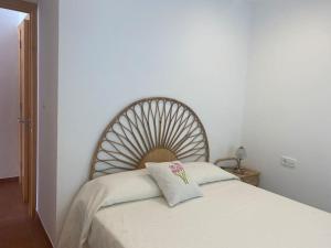 uma cama branca com uma almofada em cima em Apartamento en Na Macaret A em Na Macaret