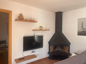 uma sala de estar com televisão e lareira em Apartamento en Na Macaret A em Na Macaret