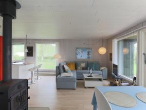 een woonkamer met een bank en een fornuis bij Holiday Home Kalle - 400m from the sea in Funen by Interhome in Hårby