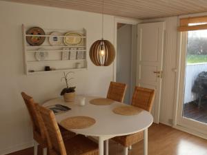 uma sala de jantar com uma mesa branca e cadeiras em Holiday Home Susette - 400m from the sea in SE Jutland by Interhome em Haderslev