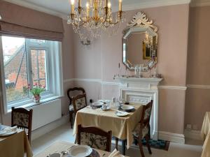 een eetkamer met een tafel en een spiegel bij Albury House in Cromer