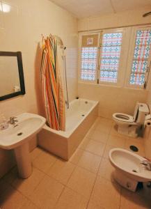 a bathroom with a tub and a toilet and a sink at La Merced Centro Rooms in Málaga