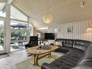 salon ze skórzaną kanapą i stołem w obiekcie Holiday Home Rathi - 250m from the sea in Funen by Interhome w mieście Hårby