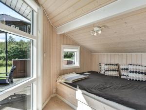 łóżko w małym domku z oknem w obiekcie Holiday Home Rathi - 250m from the sea in Funen by Interhome w mieście Hårby