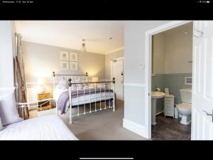 a bedroom with a bed and a sink and a toilet at Albury House in Cromer +16 photos