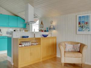 een keuken met blauwe kasten en een stoel bij Holiday Home Heimeram - 150m from the sea in SE Jutland by Interhome in Hejls