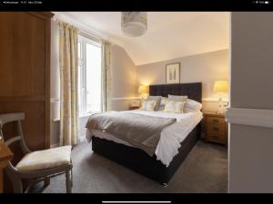 a bedroom with a bed and a chair and a window at Albury House in Cromer