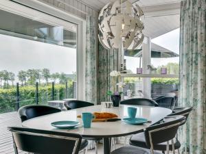een eetkamer met een tafel en stoelen en een groot raam bij Holiday Home Aasta - 250m from the sea in SE Jutland by Interhome in Binderup Strand