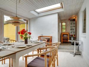 a dining room with a table and chairs at Holiday Home Gytta - 1km from the sea in Funen by Interhome in Tranekær