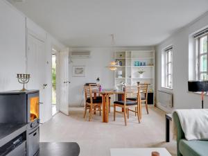 a dining room and living room with a table and chairs at Holiday Home Gytta - 1km from the sea in Funen by Interhome in Tranekær