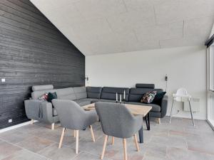 a living room with a couch and a table and chairs at Holiday Home Helina - 180m from the sea in SE Jutland by Interhome in Haderslev