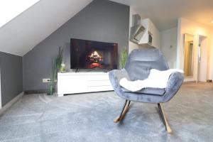 een blauwe stoel in een woonkamer met een open haard bij Wernerwaldstr-1 in Cuxhaven