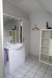 uma casa de banho branca com um lavatório e um espelho em Wernerwaldstr-1 em Cuxhaven