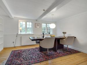 jadalnia ze stołem i krzesłami na dywanie w obiekcie Holiday Home Ilsa - 9-8km from the sea in Western Jutland by Interhome w mieście Tønder
