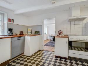 una cucina con elettrodomestici bianchi e un pavimento a scacchi di Holiday Home Ilsa - 9-8km from the sea in Western Jutland by Interhome a Tønder