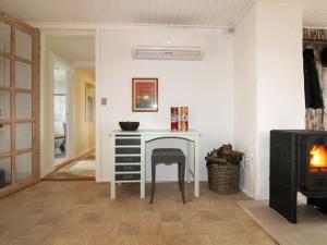 a room with a table and a chair and a stove at Holiday Home Harre - 300m from the sea in Funen by Interhome in Rudkøbing