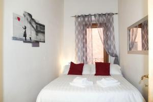 una camera da letto con un letto con cuscini rossi e una finestra di Blue Navona Two Bedroom Apartment a Roma