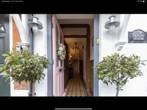 a hallway of a building with a door and two plants at Albury House in Cromer