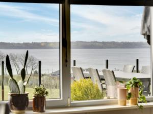 a window with chairs and a view of the water at Holiday Home Karli - 330m to the inlet in SE Jutland by Interhome in Aabenraa