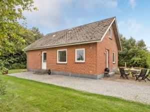 a red brick house with a patio and a table at Holiday Home Ewelina - 15km from the sea in Western Jutland by Interhome in Ballum