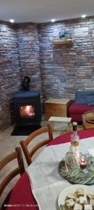 a living room with a fireplace and a table with food at Kuća za odmor Denis in Mala Lešnica