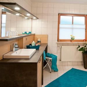 a bathroom with a sink and a mirror at Ferienwohnungen Renner in Viereth-Trunstadt +21 photos