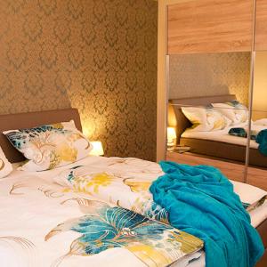 a bed with a blue blanket on it in a bedroom at Ferienwohnungen Renner in Viereth-Trunstadt