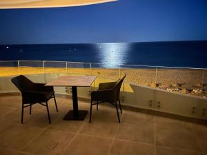 a table and chairs in a room with the ocean at Villamar in Salema