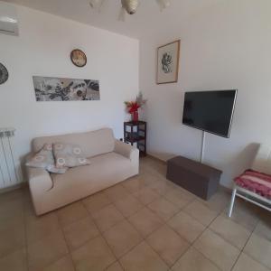 a living room with a couch and a flat screen tv at appartamento dei pioppi in Pescara