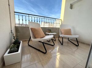 2 sillas sentadas en el balcón de un apartamento en Salty Apartment Torrevieja, en Torrevieja