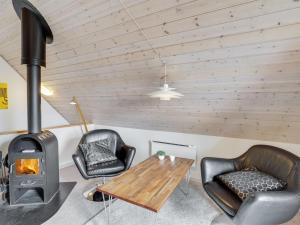 sala de estar con estufa de leña y sillas en Holiday Home Uffe - 200m to the inlet in SE Jutland by Interhome, en Gråsten
