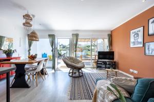 ein Wohnzimmer mit orangefarbenen Wänden sowie einem Tisch und Stühlen in der Unterkunft Casa da Amoreira in Aljezur