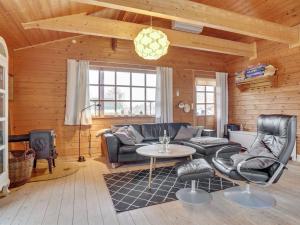 een woonkamer met een bank en een tafel bij Holiday Home Baldo - 100m from the sea in SE Jutland by Interhome in Broager