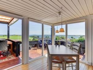 jadalnia ze stołem i widokiem na ocean w obiekcie Holiday Home Axeln - 300m to the inlet in SE Jutland by Interhome w mieście Aabenraa