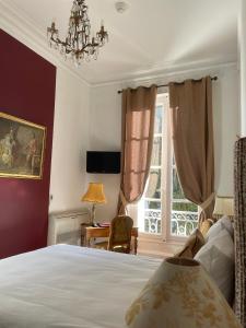 um quarto com uma cama e uma janela em Hôtel Château des Jacobins em Agen