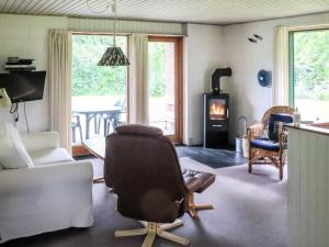 ein Wohnzimmer mit einem Stuhl und einem Kamin in der Unterkunft Holiday Home Ismo - 30km from the sea in Western Jutland by Interhome in Toftlund
