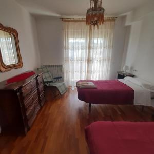 a bedroom with two beds and a dresser and a mirror at appartamento dei pioppi in Pescara