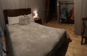um quarto com uma grande cama branca e 2 almofadas em EL TRAPICHE em Sigchos
