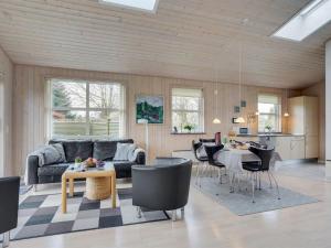 een woonkamer met een bank en een tafel en stoelen bij Holiday Home Flete - 200m from the sea in SE Jutland by Interhome in Neder Lysabild