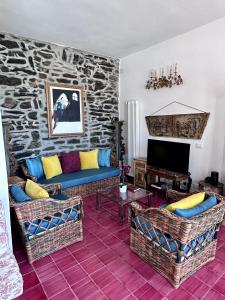 a living room with two couches and a stone wall at Il Conventino delle Cinque Terre - Sea View - AC&WiFi - Vernazzarentals in Vernazza