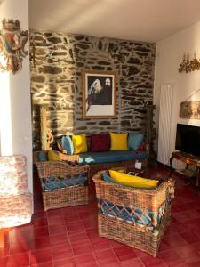 a living room with a couch and a stone wall at Il Conventino delle Cinque Terre - Sea View - AC&WiFi - Vernazzarentals in Vernazza