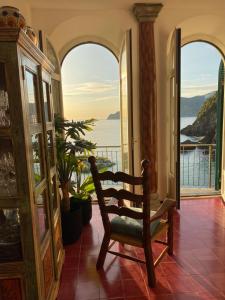 a chair in a room with a view of the ocean at Il Conventino delle Cinque Terre - Sea View - AC&WiFi - Vernazzarentals in Vernazza