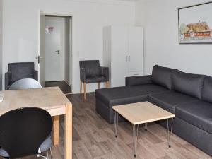 a living room with a couch and a table and chairs at Apartment Annicka - 5km from the sea in Western Jutland by Interhome in Kongsmark