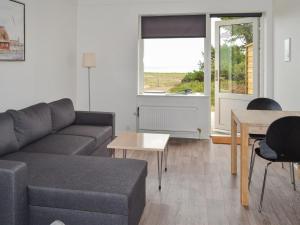 a living room with a couch and a table at Apartment Annicka - 5km from the sea in Western Jutland by Interhome in Kongsmark