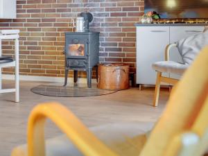 a stove in a living room with a brick wall at Holiday Home Pance - 20km to the inlet in Western Jutland by Interhome in Toftlund