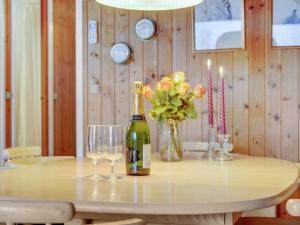 a table with a bottle of wine and two glasses at Holiday Home Pance - 20km to the inlet in Western Jutland by Interhome in Toftlund