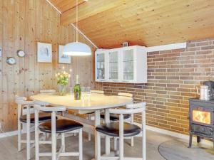 a kitchen with a table and chairs and a brick wall at Holiday Home Pance - 20km to the inlet in Western Jutland by Interhome in Toftlund