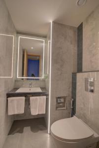 uma casa de banho com um WC, um lavatório e um espelho. em 7 Apple Hotel Nashik em Nashik