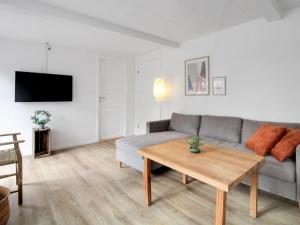 ein Wohnzimmer mit einem Sofa und einem Tisch in der Unterkunft Holiday Home Dolfine - 15km from the sea in Western Jutland by Interhome in Skærbæk