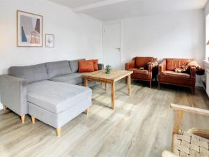 ein Wohnzimmer mit einem Sofa und einem Tisch in der Unterkunft Holiday Home Dolfine - 15km from the sea in Western Jutland by Interhome in Skærbæk